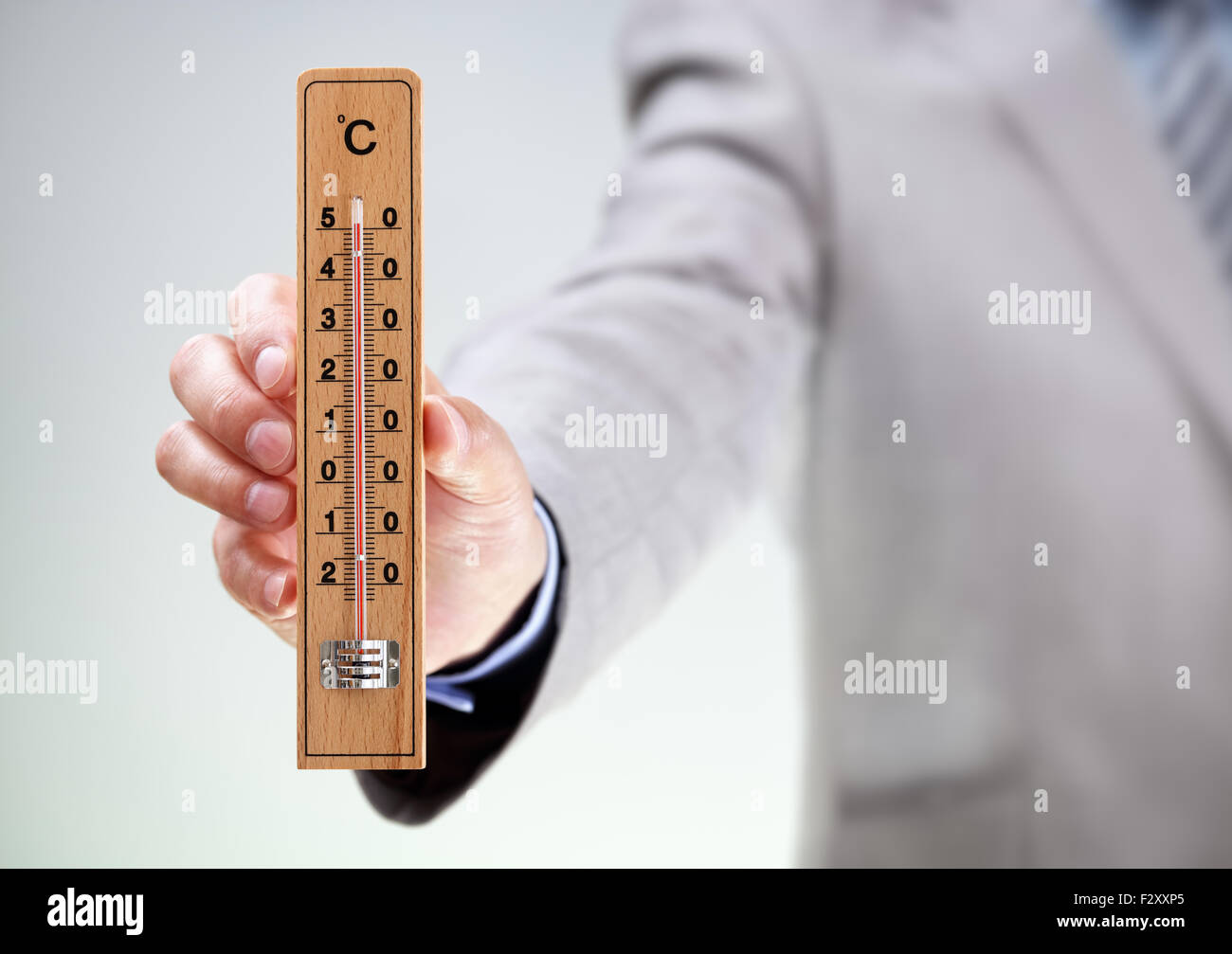 Geschäftsmann hält Thermometer messen Hochtemperatur-Konzept für Klima, Stress, unter Druck oder Frist Stockfoto