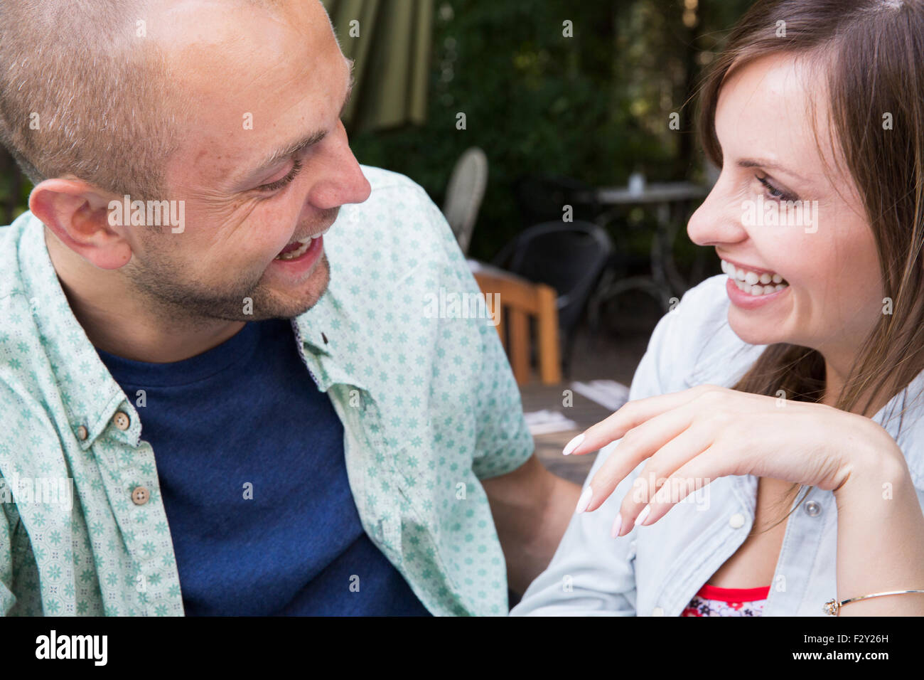 Ein junger Mann und Frau, ein paar sitzen draußen in einem Café zusammen. Stockfoto