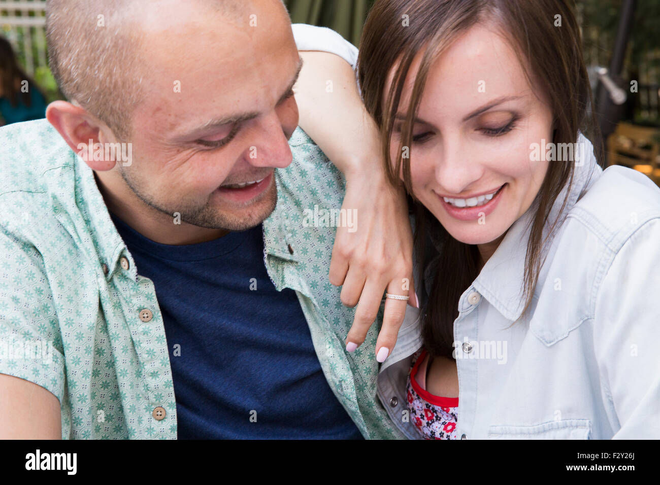 Ein junger Mann und Frau, ein paar sitzen draußen in einem Café zusammen. Stockfoto