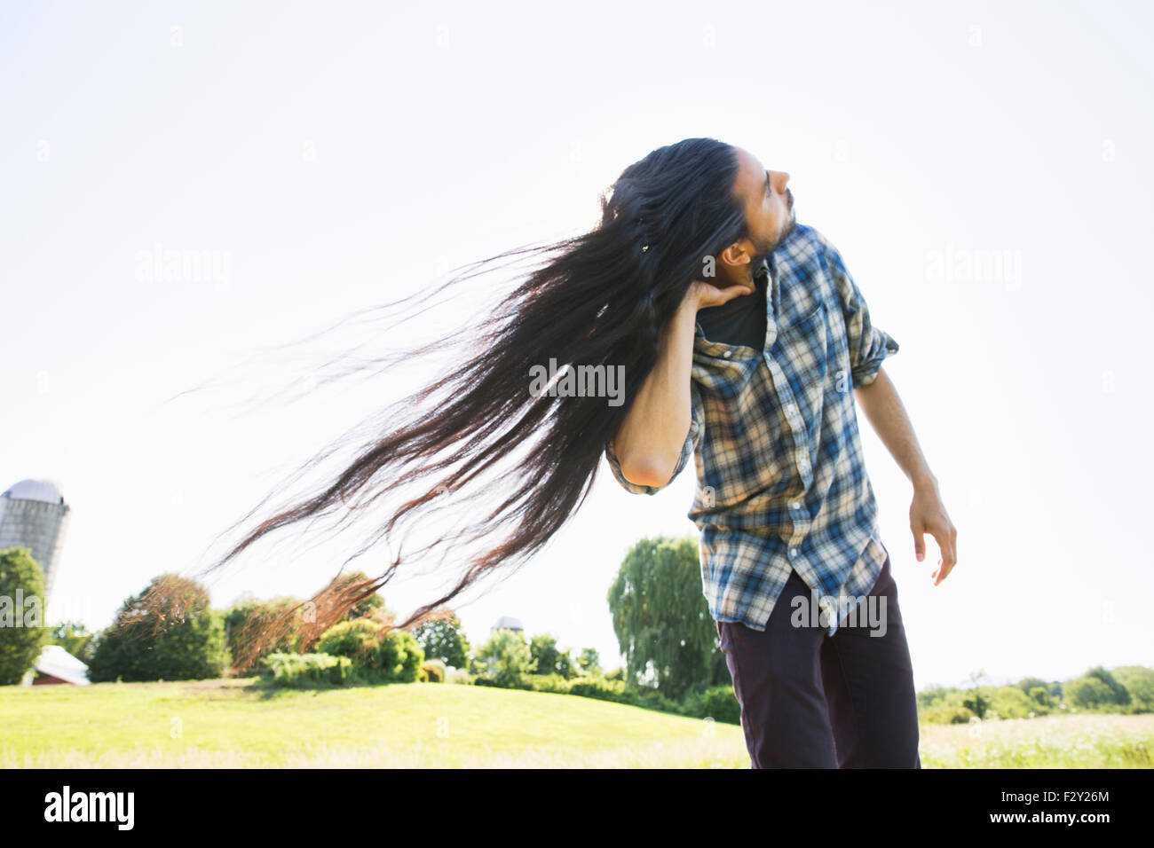 Ein junger Mann schüttelt den Kopf mit Hisl Ong Haar im Wind. Stockfoto