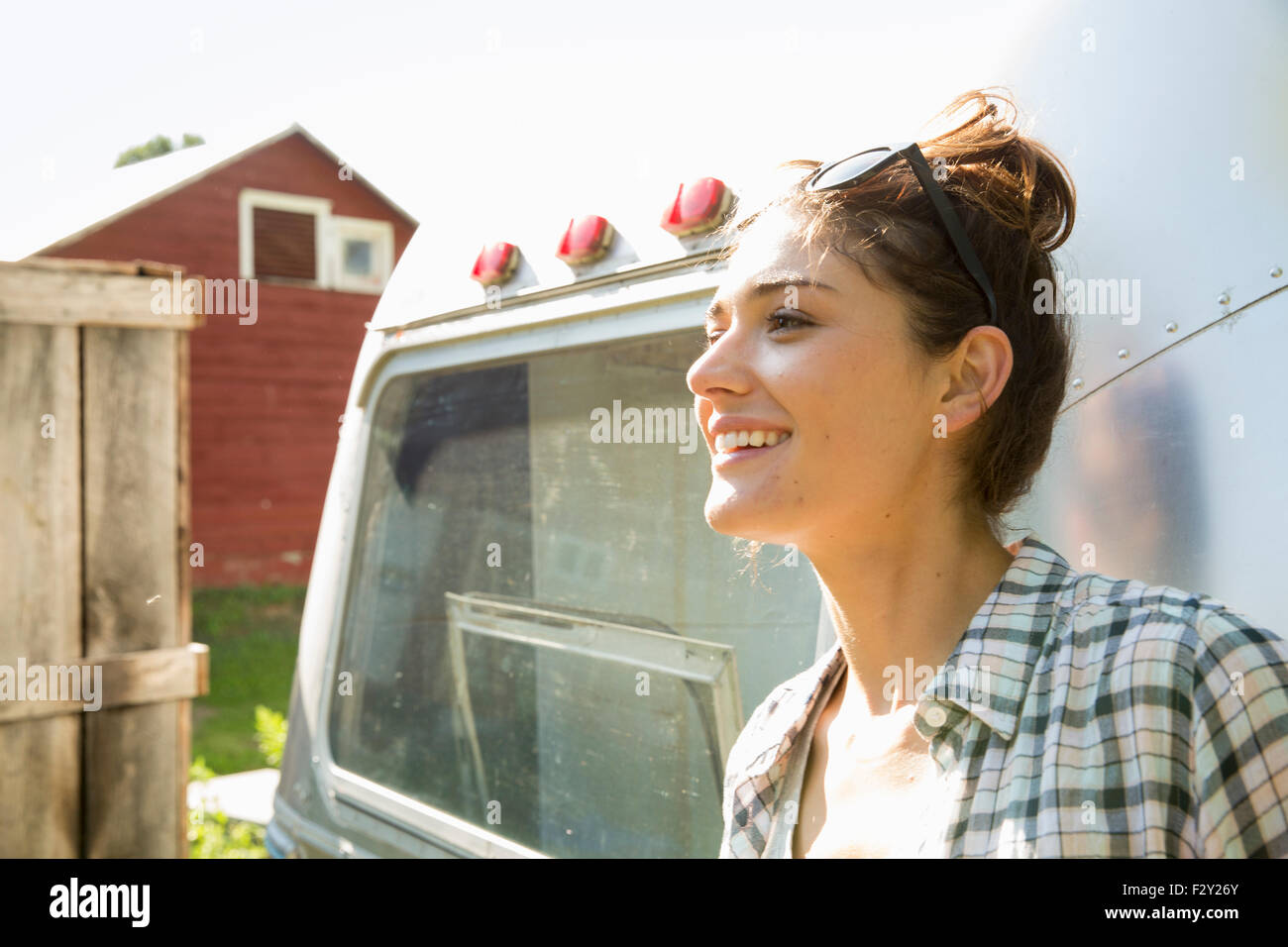 Eine junge Frau mit Sonnenbrille von einem Silber farbigen Anhänger. Stockfoto