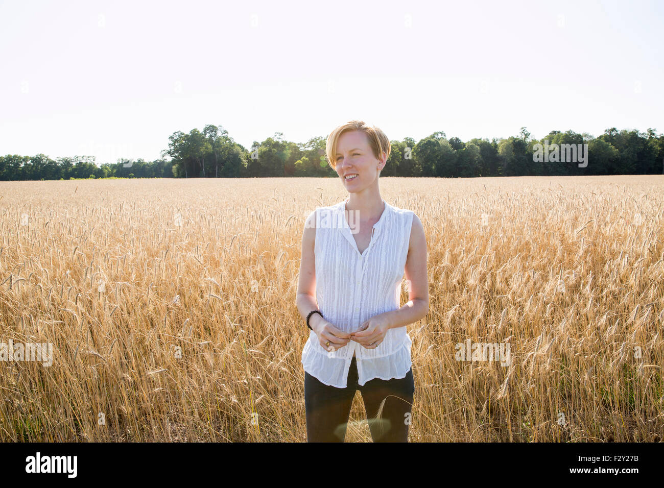 Halblängen Porträt einer jungen Frau, stehend in einem Maisfeld. Stockfoto