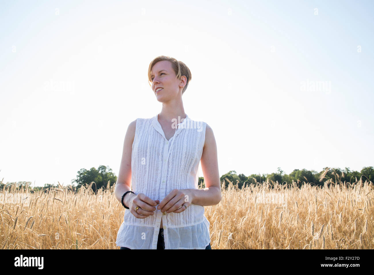 Halblängen Porträt einer jungen Frau, stehend in einem Maisfeld. Stockfoto