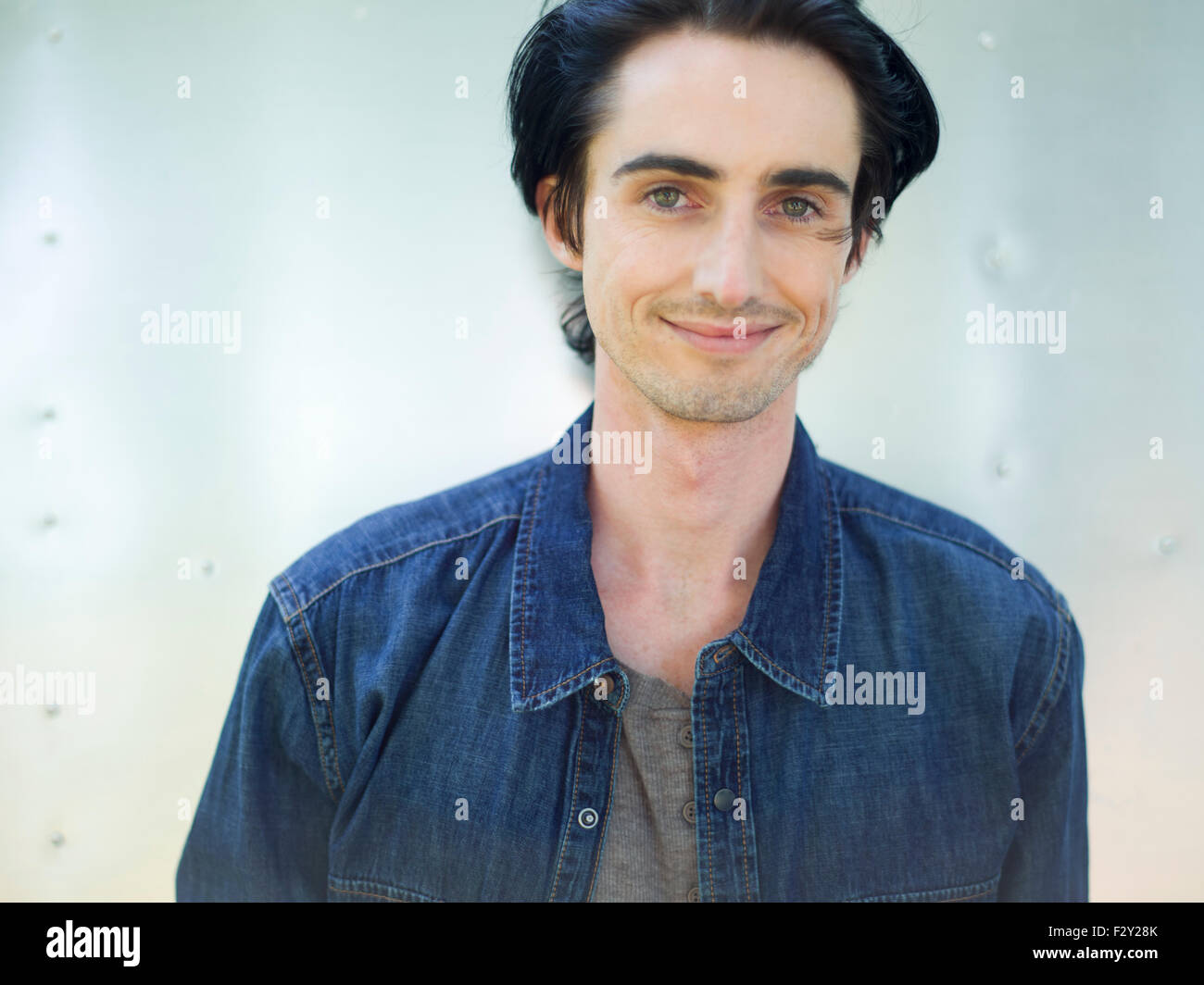 Ein junger Mann trägt ein Jeanshemd und Hut. Stockfoto