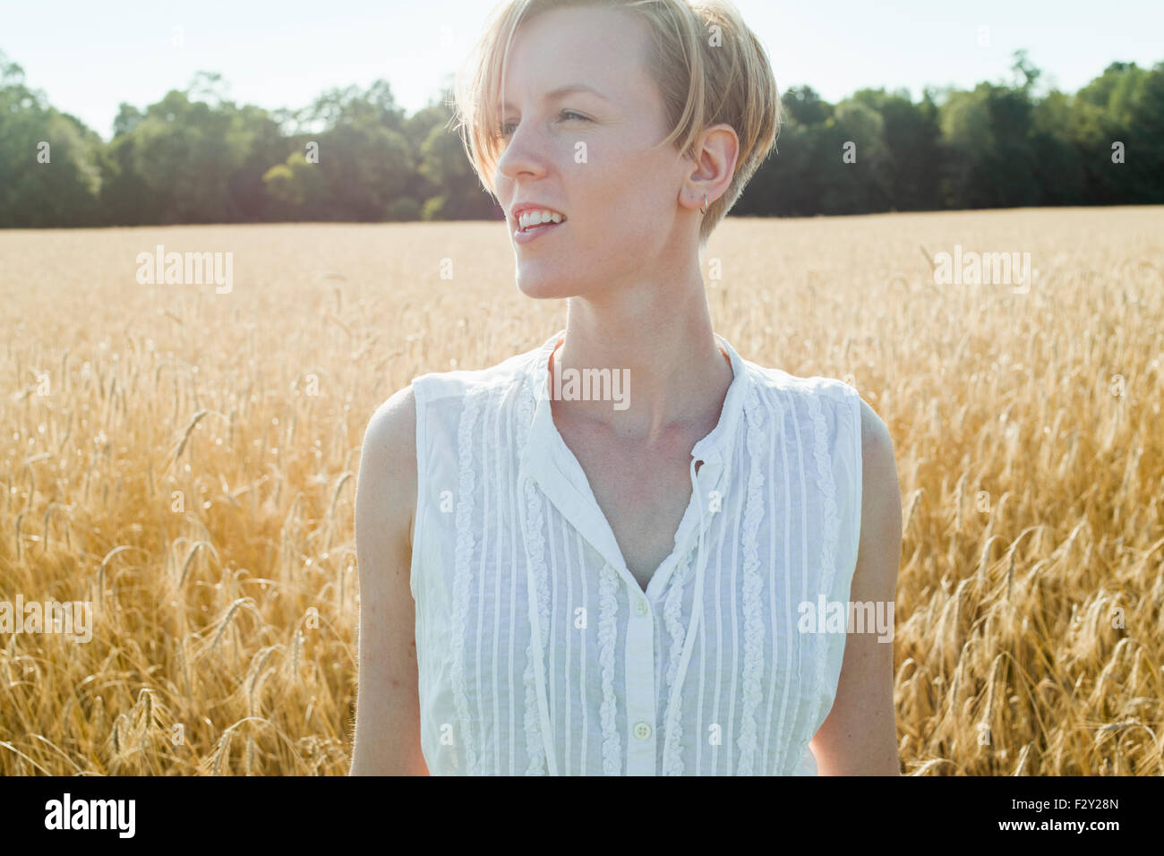Eine junge Frau in einem Maisfeld suchen um sie herum, Stockfoto