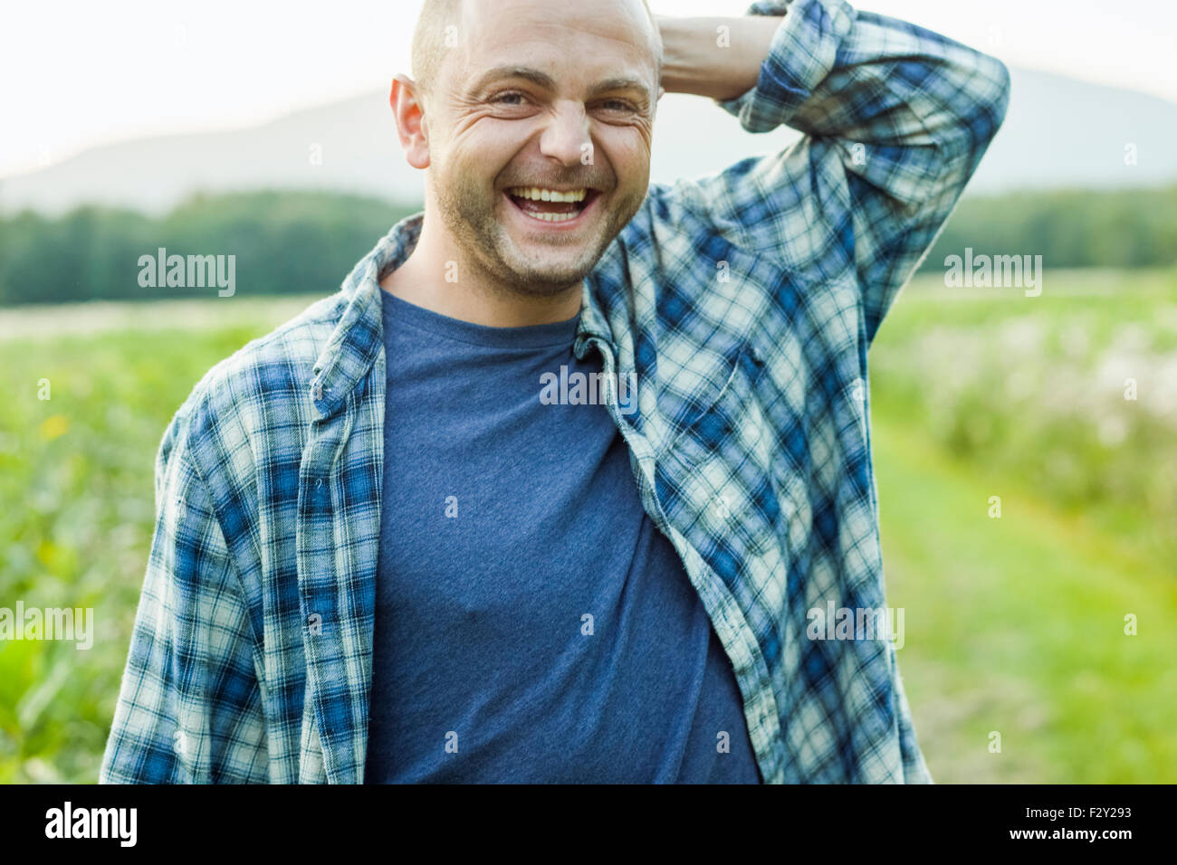 Ein Mann im Freien in eine Wildblumenwiese trägt ein kariertes Hemd. Stockfoto