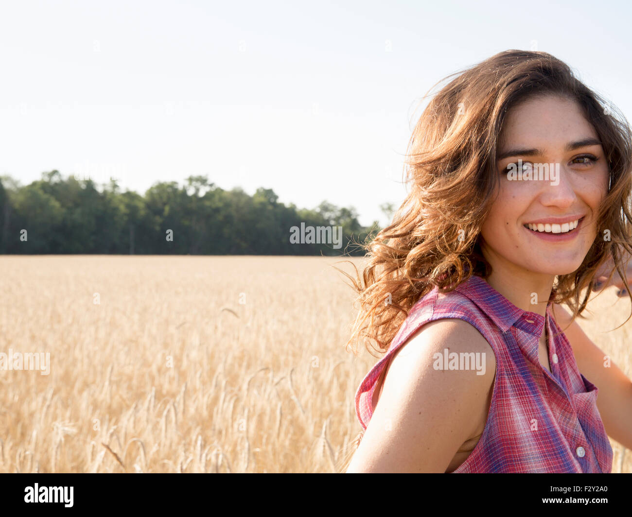 Junge Frau in einem Maisfeld in die Kamera Lächeln. Stockfoto