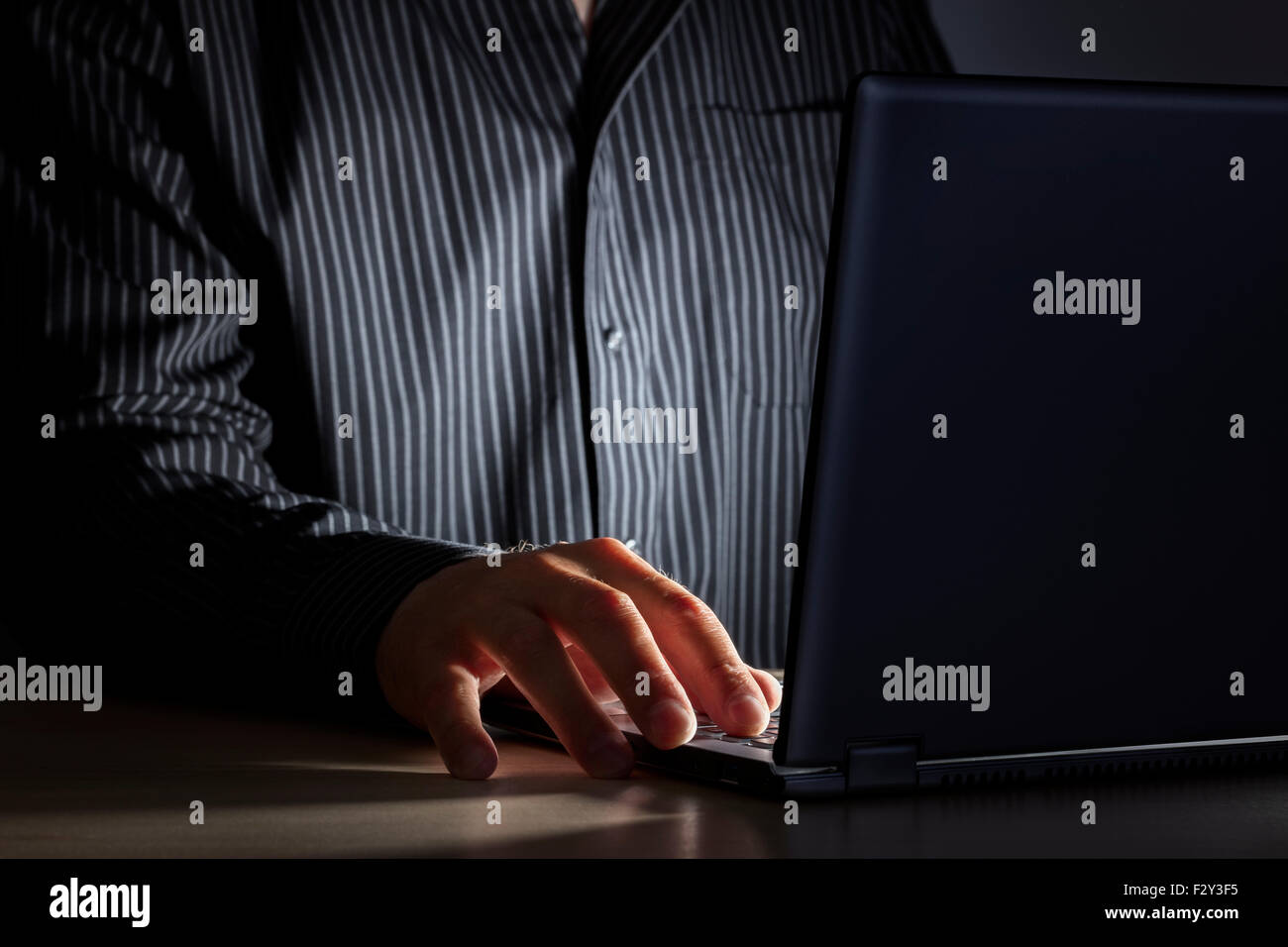 Spät in der Nacht Internet sucht oder arbeiten spät Mann mit Laptop an einem Schreibtisch in der Dunkelheit Stockfoto