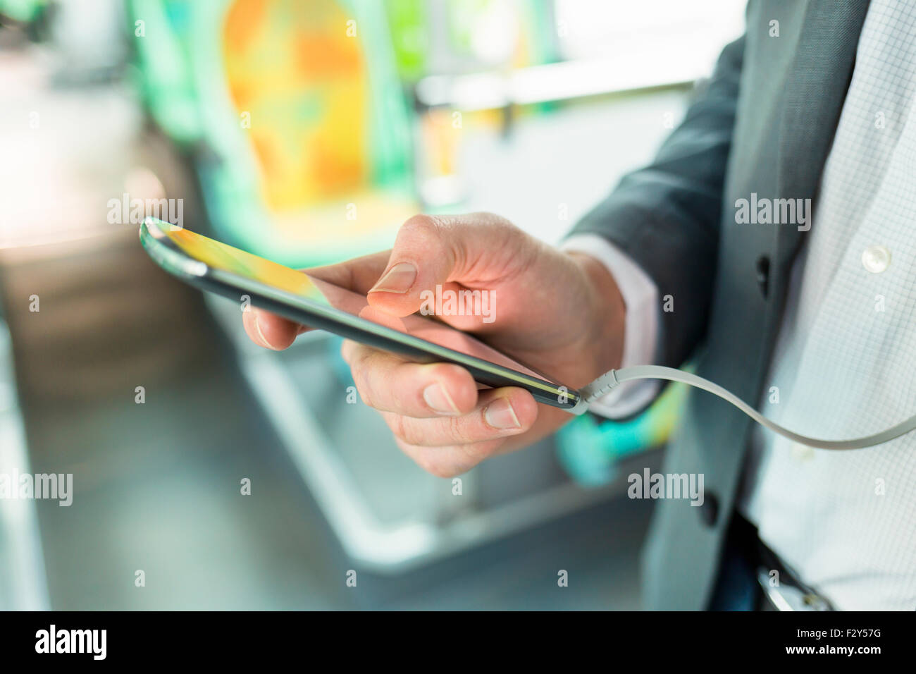 Mann mit Handy Musik zu hören. am Bus. SMS-Nachricht. Close-up Hände Stockfoto
