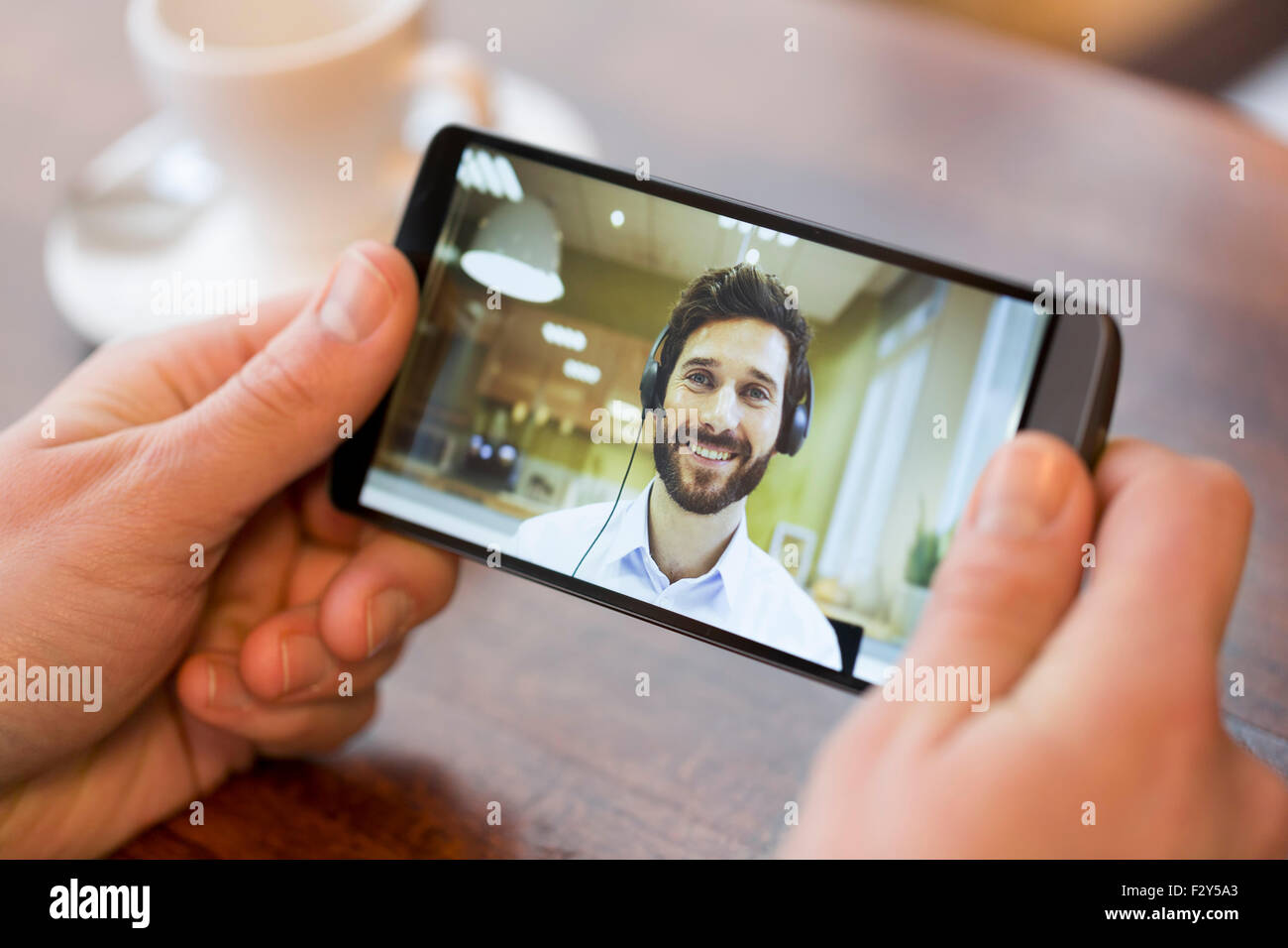 Nahaufnahme einer männlichen Hand hält ein intelligentes Telefon während einer Skype video Stockfoto