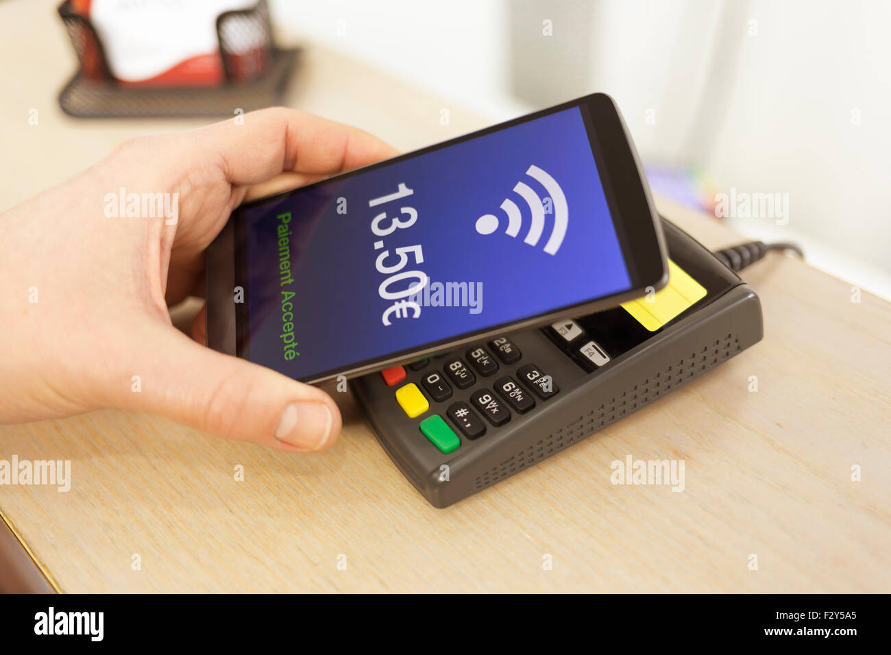 Mann mit NFC-Technologie auf dem Handy zu bezahlen. Euro-version Stockfoto