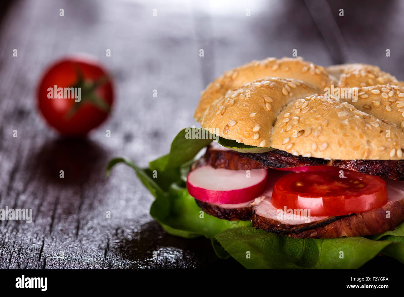 Leckere Sandwich gefüllt mit Schinken und Gemüse auf hölzernen Hintergrund Stockfoto