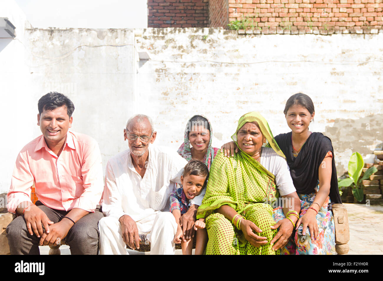 indische Gruppe Massen ländlichen Dorfbewohner Familie sitzt Hause Charpai Stockfoto