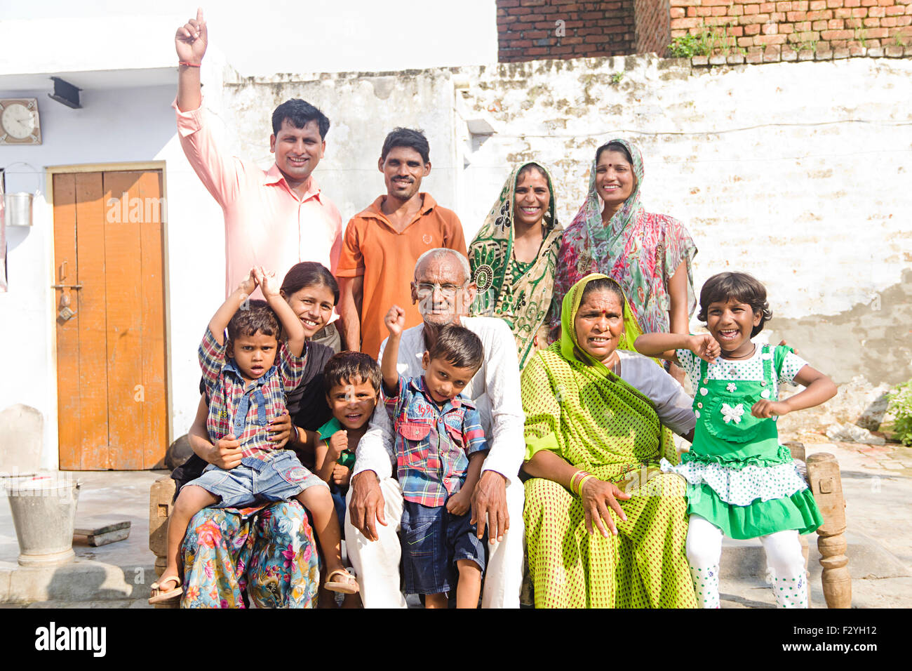 indische Gruppe Massen ländlichen Dorfbewohner gemeinsame Familie Zuhause sitzen Charpai Stockfoto