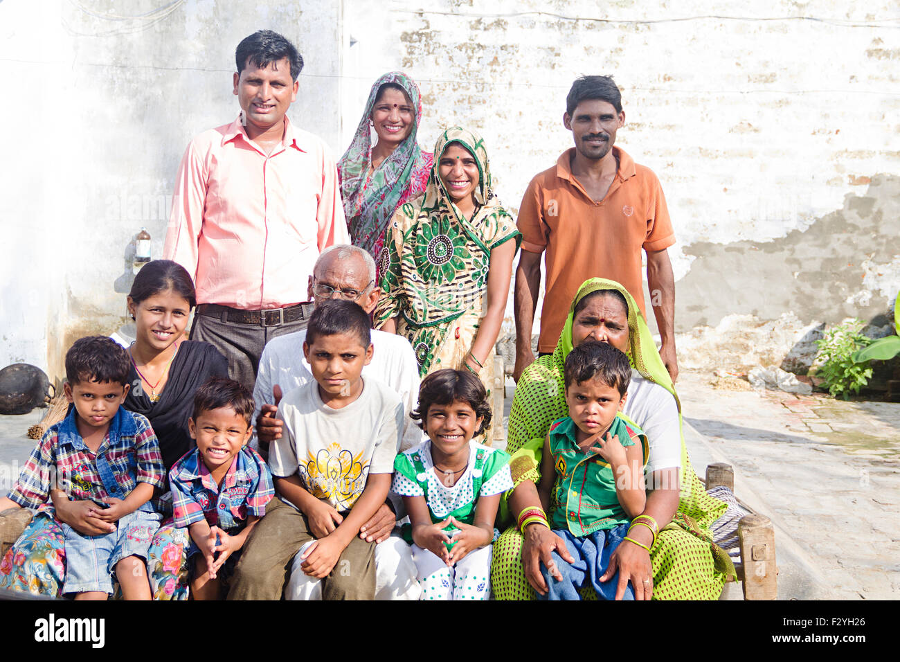 indische Gruppe Massen ländlichen Dorfbewohner gemeinsame Familie Zuhause sitzen Charpai Stockfoto