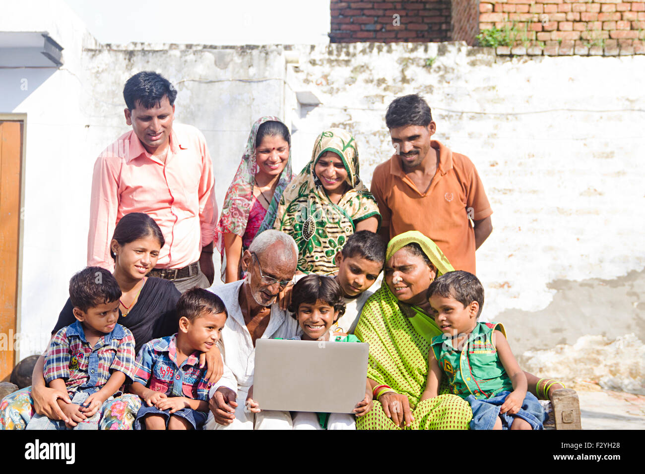 indische Gruppe Massen ländlichen Dorfbewohner gemeinsame Familie Zuhause sitzen Laptop arbeiten Stockfoto