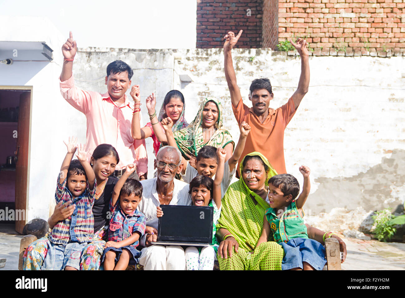indische Gruppe Massen ländlichen Dorfbewohner gemeinsame Familie Hause Laptop zeigt Stockfoto