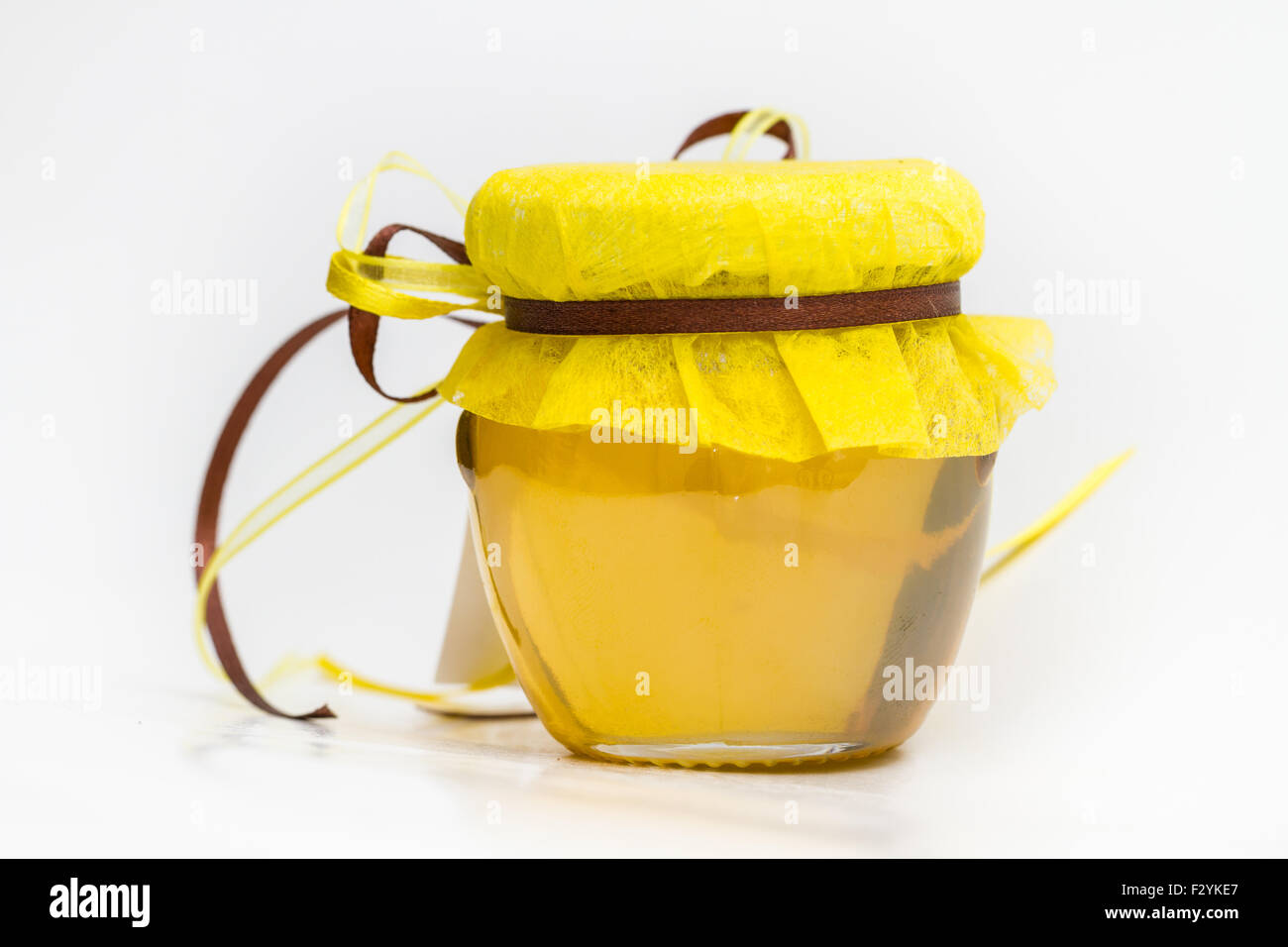 Kräuterhonig in Glas mit kleinen Waben und Kräutern isoliert auf weißem Hintergrund Stockfoto