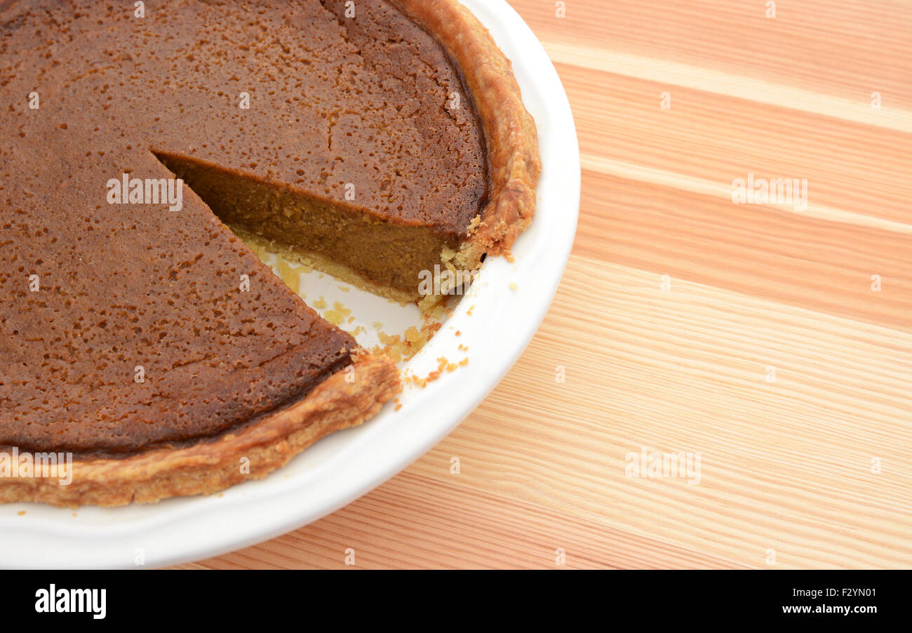 Nahaufnahme des geschnittenen Kürbis-Kuchen mit einer Scheibe auf einem Holztisch genommen Stockfoto