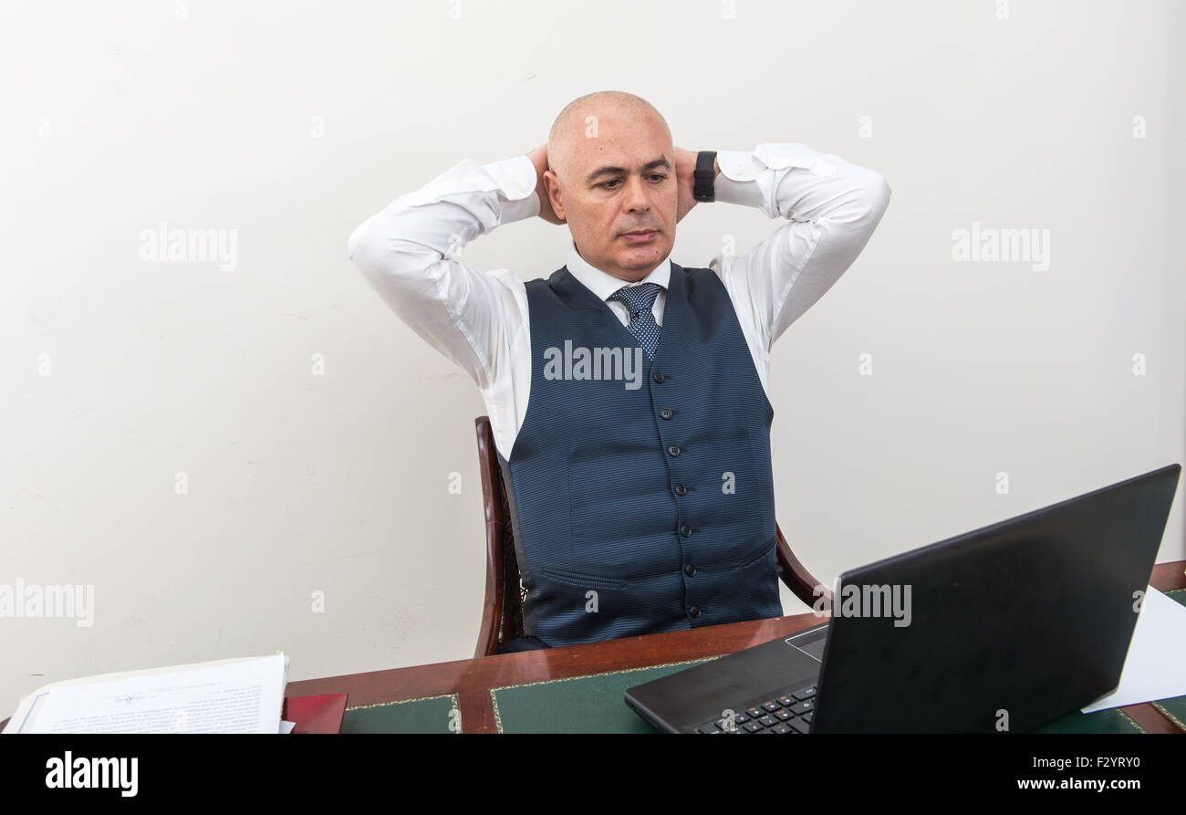 Ein quälender Geschäftsmann in der Krise, vor seinem pc. In seinem Arbeitszimmer, allein mit seiner Verzweiflung und seine Panik. Stockfoto