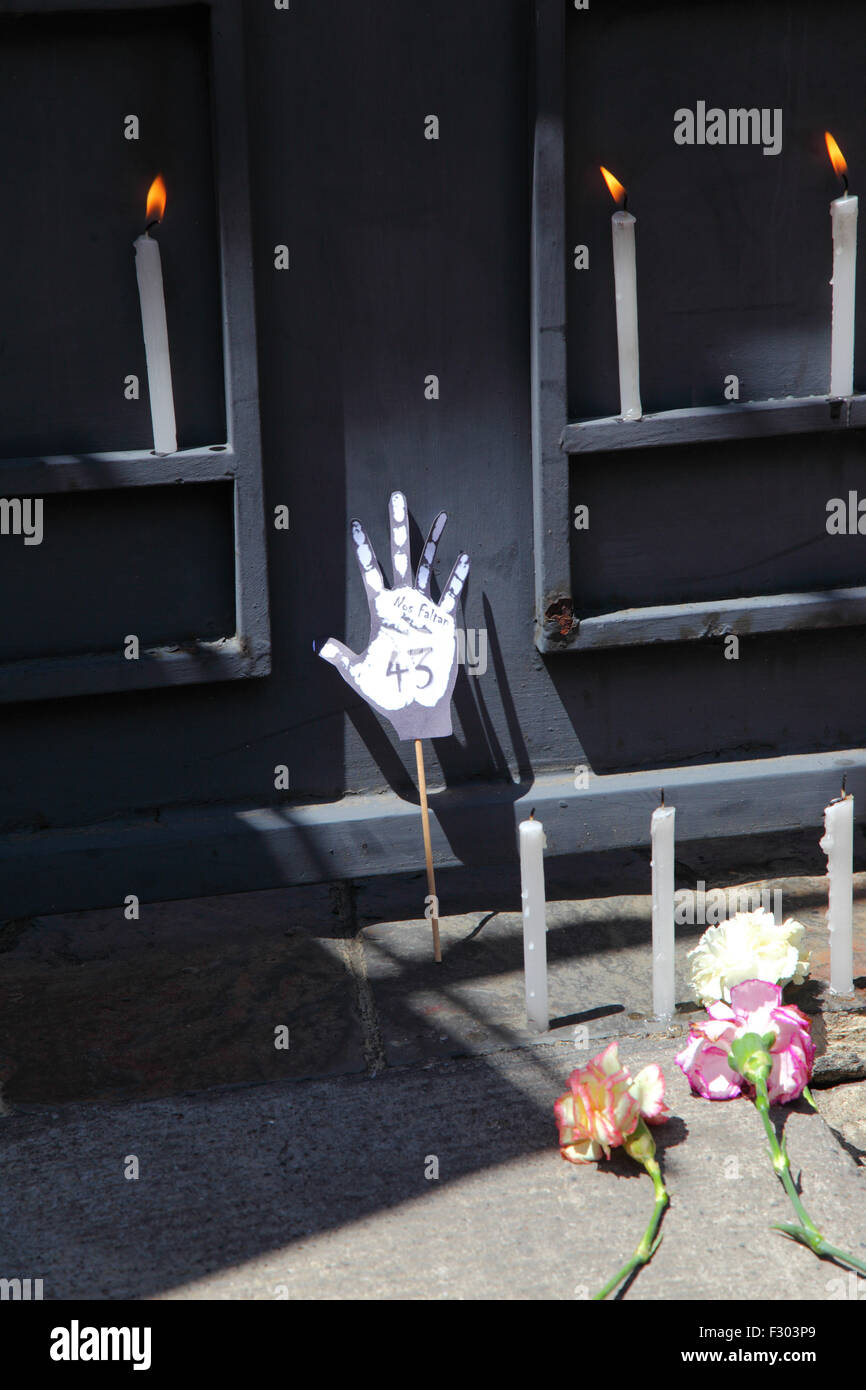 La Paz, Bolivien, 26. September 2015. Ein Handsymbol aus weißem Papier, Kerzen und Nelken vor dem Eingang der mexikanischen Botschaft in La Paz zum ersten Jahrestag des Verschwindens von 43 Studenten in Mexiko. Die Schüler, die von einer Lehrerschule in Ayotzinapa stammten, verschwanden in der Nacht des 26. September 2014 in der Stadt Iguala im Bundesstaat Guerrero. Die Behandlung des Falls durch die mexikanische Regierung wurde weithin kritisiert, und ein Team der Interamerikanischen Menschenrechtskommission fand eine Reihe von Fehlern in der Untersuchung der Regierung. Stockfoto