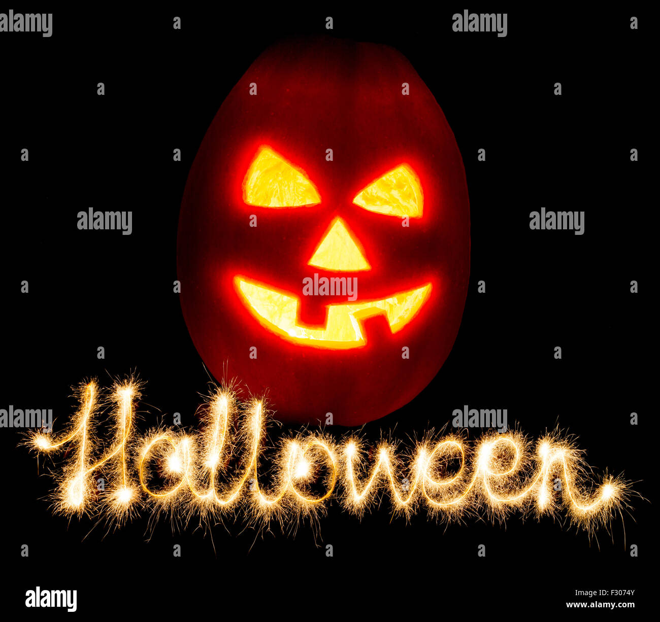 Halloween Kürbis Jack-o-Laterne Kerze angezündet und die Inschrift Halloween Wunderkerzen, auf schwarzem Hintergrund isoliert Stockfoto