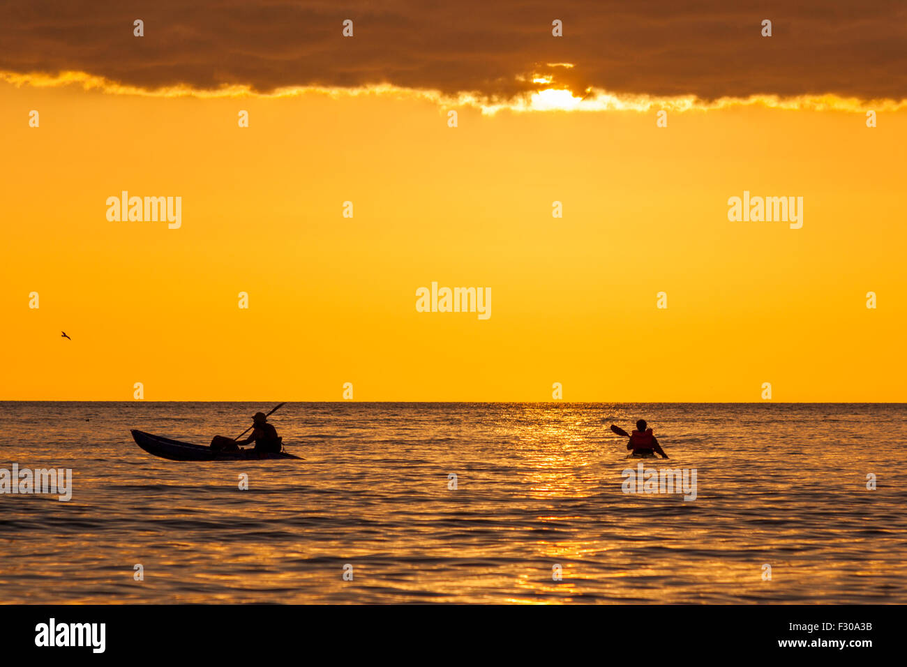 2 Leute da draußen auf dem Meer in ihrem Kanu & bei Sonnenuntergang einfach schmuddelig off Aberystwyth Ceredigion Wales UK Stockfoto
