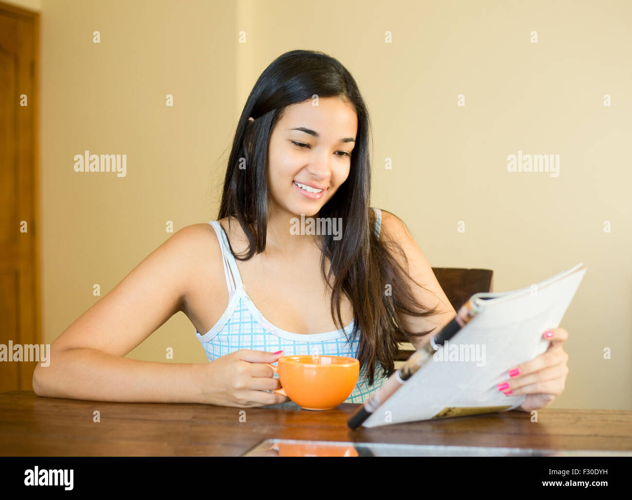 junge Frau mit einem Kaffee lesen einer Zeitschrift Stockfoto