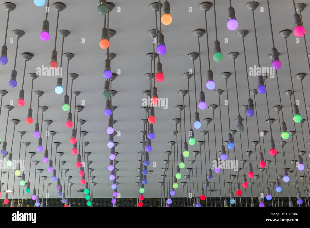 Installation von bunten Glühbirnen an der Decke Stockfoto