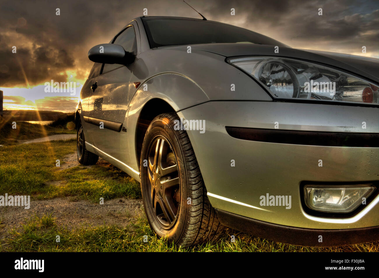 Ein Bild von einem Ford Focus bei Sonnenuntergang an der Küste von Cornwall. Stockfoto