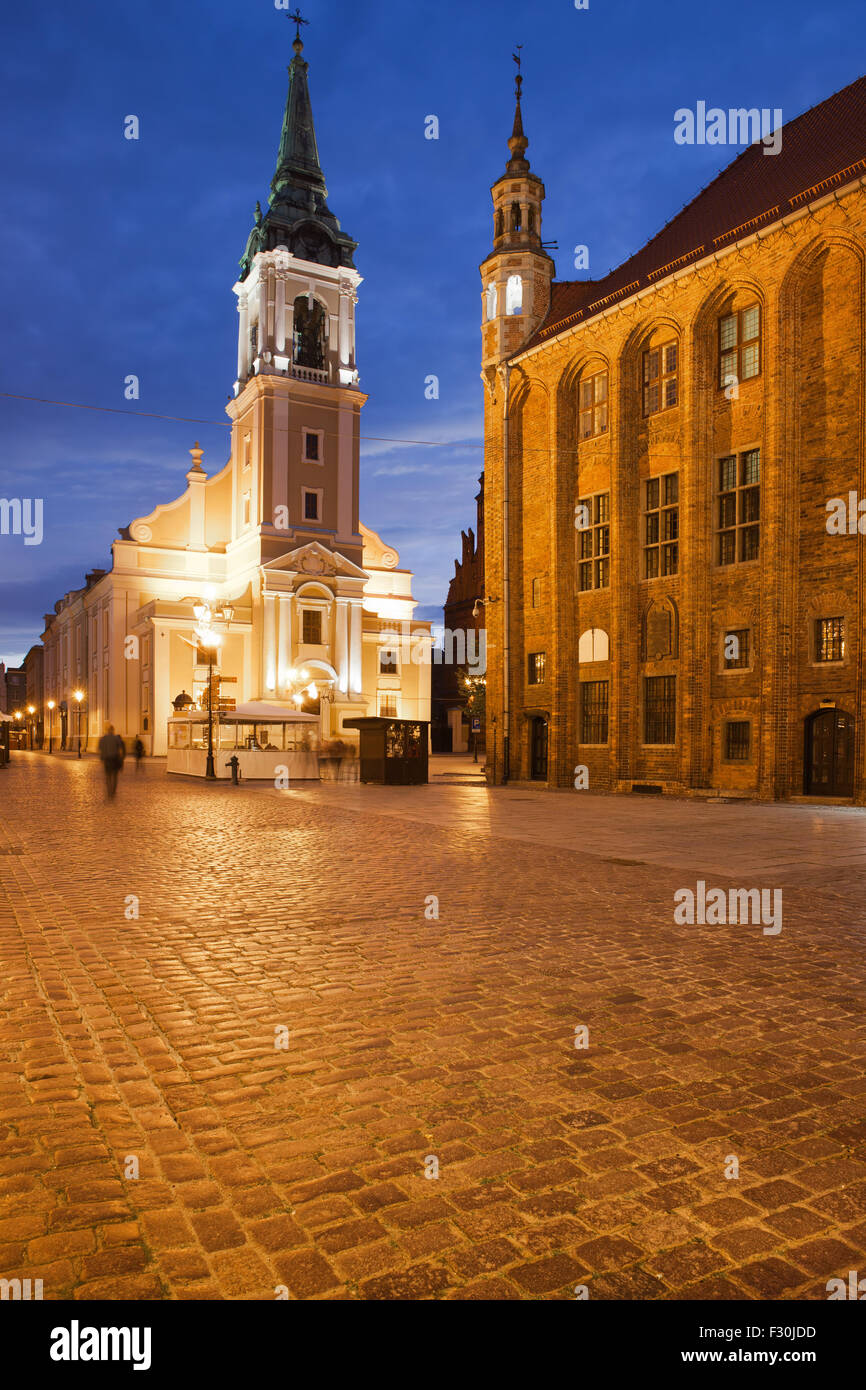 Kirche des Heiligen Geistes und alte Rathaus am Marktplatz in der Nacht in Torun, Polen. Stockfoto