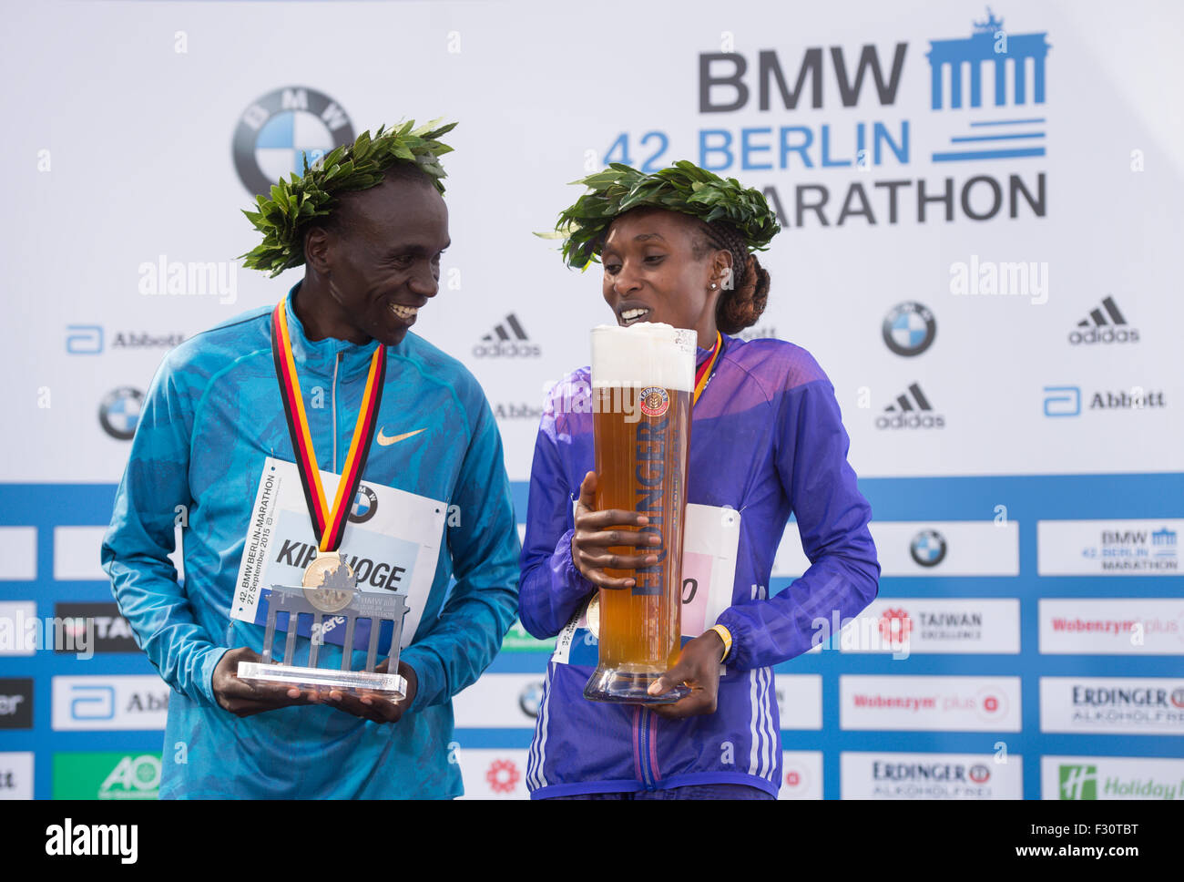 Berlin, Deutschland. 27. Sep, 2015. Gewinner Eliud Kipchoge (L) von Kenia ein Gladys Cherono Kenias feiern ihren Sieg auf dem Podium bei der 42. Berlin-Marathon in Berlin, Deutschland, 27. September 2015. Foto: Bernd von Jutrczenka/Dpa/Alamy Live News Stockfoto