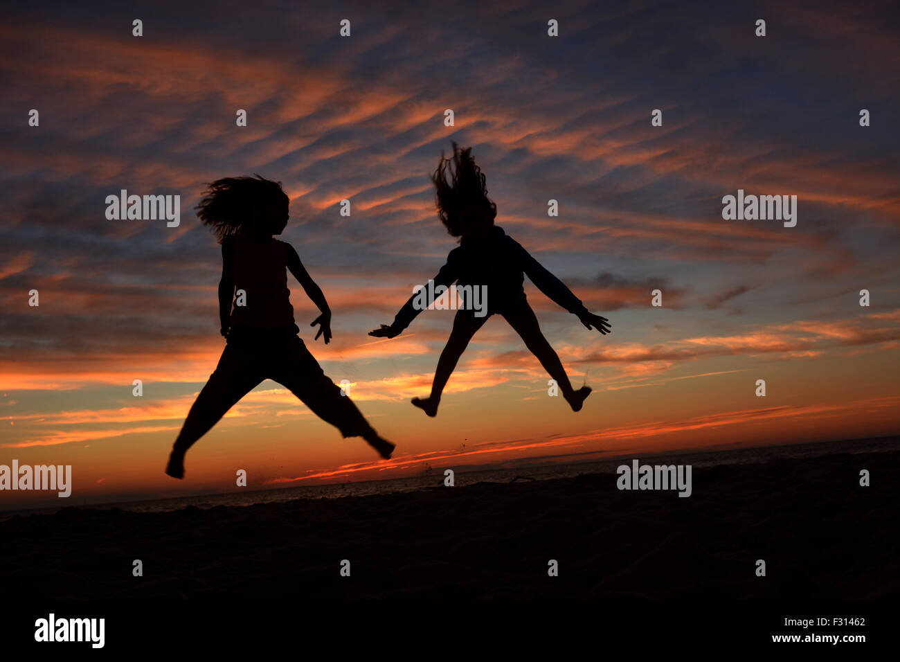 Kinder silhouette, wie sie springen und genießen Sie den Sonnenuntergang Stockfoto