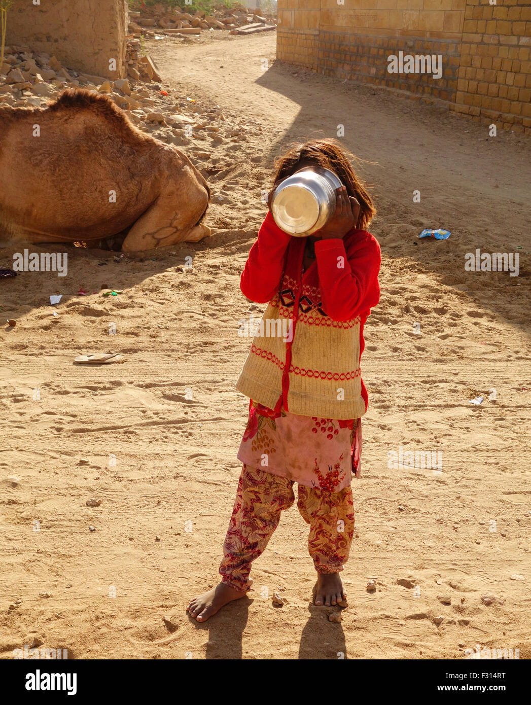 Einen armen indischen Mädchen verstecken Gesicht mit Utensilien in khuri, Jaisalmer, Rajasthan Stockfoto