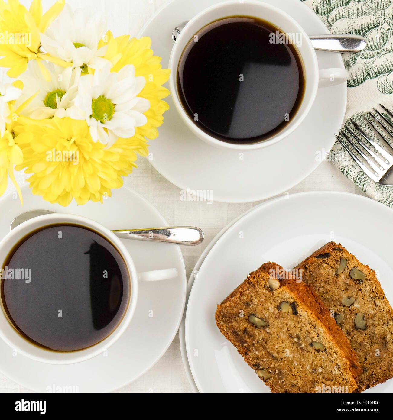 Kaffee und ein leckeres Stück von Gluten freie Datum und Walnuss Brot Kuchen, hübsches Tischgesteck. Stockfoto