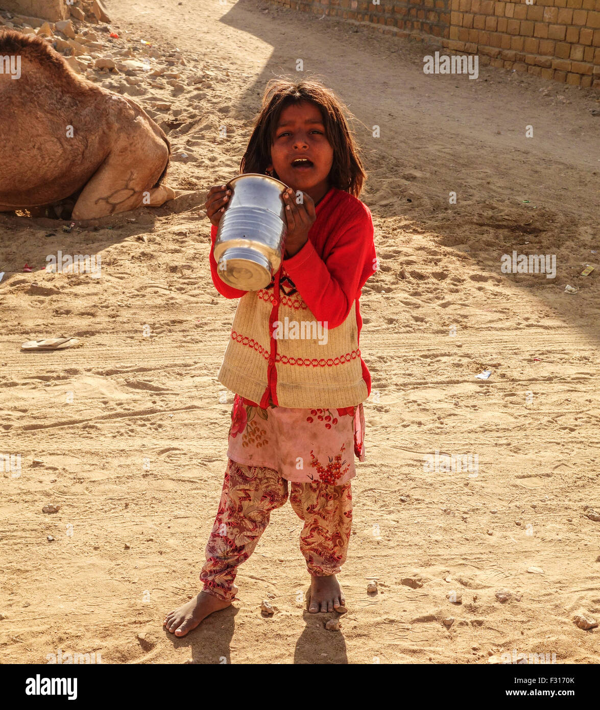 Einen armen indischen Mädchen traurig Holding Utensil in der Hand in khuri, Jaisalmer, Rajasthan Stockfoto