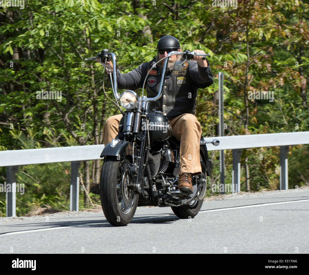 Mann reitet einen alten antiken Vintage Harley Davidson mit Ape Hanger Lenker und Springer-front-End. Stockfoto