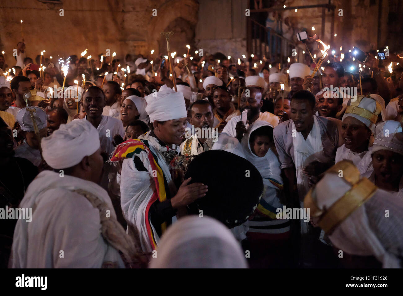 Äthiopisch-orthodoxe Christen halten die Kerze fest, während sie die ‘Demera’ feiern, Dies ist eine Zeremonie der Meskel - Entdeckung des wahren Kreuzes durch die heilige Helena im vierten Jahrhundert n. Chr., die am 27. September 2015 in der Grabeskirche in Ostjerusalem, Israel, durch Fackel am Deir El-Sultan Kloster auf dem Dach der Grabeskirche beobachtet wurde. Meskel, ist der geistliche Feiertag der orthodoxen Christen in Äthiopien und wird seit Tausenden von Jahren gefeiert. Sie wurde nun von der UNESCO auf die repräsentative Liste des immateriellen Kulturerbes der Menschheit gesetzt. Stockfoto