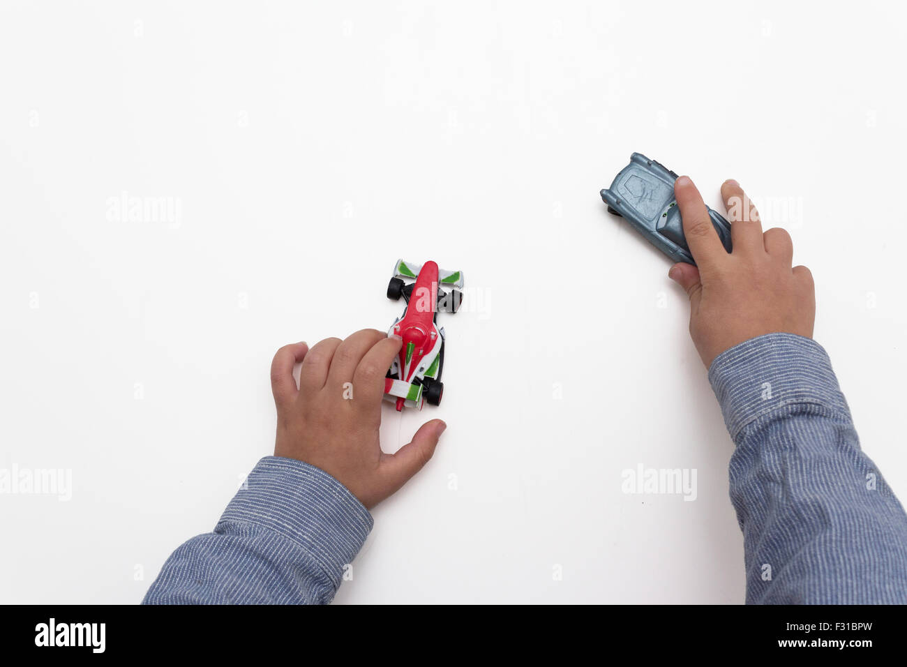 Kind die Hände isoliert spielen mit Autos auf weißem Hintergrund Stockfoto