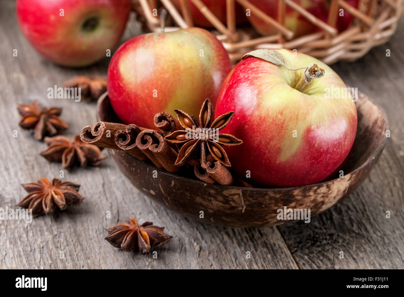 Äpfel mit Gewürzen: Zimt, Sternanis auf einem hölzernen Hintergrund Stockfoto