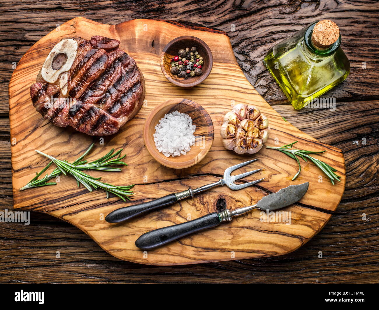 Rindersteaks mit Gewürzen auf einem Holztablett. Stockfoto