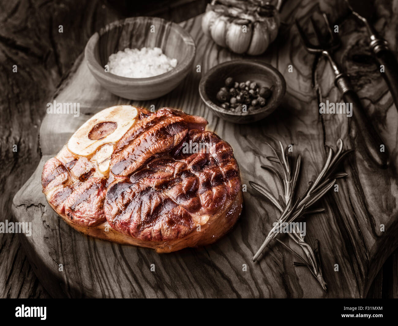 Rindersteaks mit Gewürzen auf einem Holztablett. Stockfoto