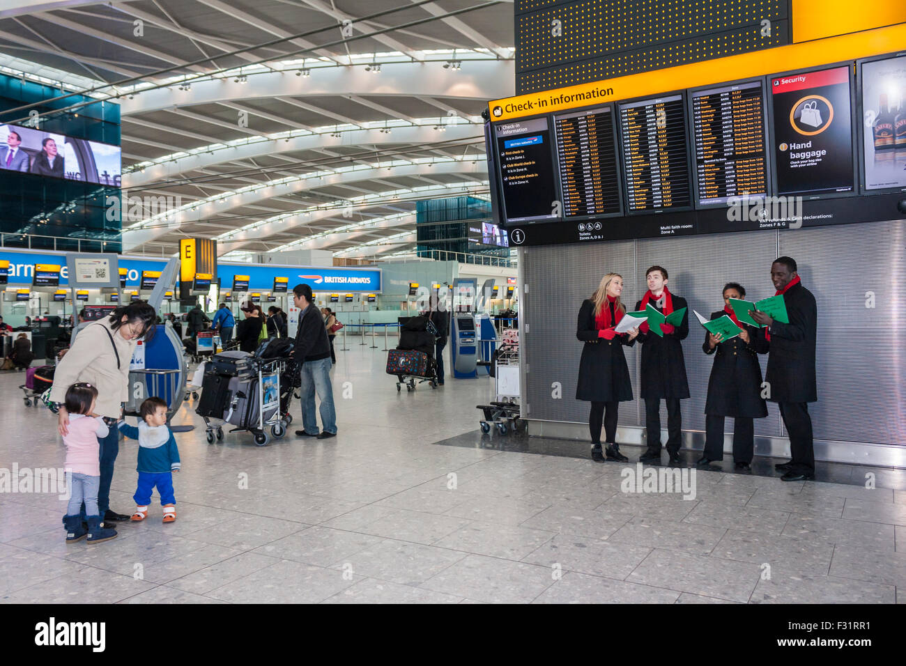 Sternsinger zu Reisenden unterhalten. T5 Flughafen Heathrow, London. Stockfoto
