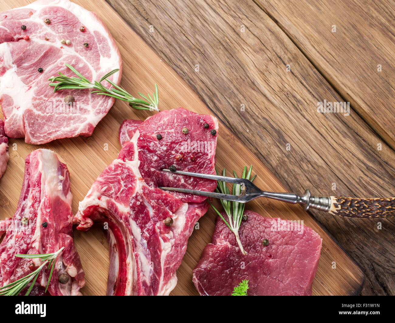 Rohes Fleisch Steaks mit Gewürzen auf dem Holzbrett. Stockfoto
