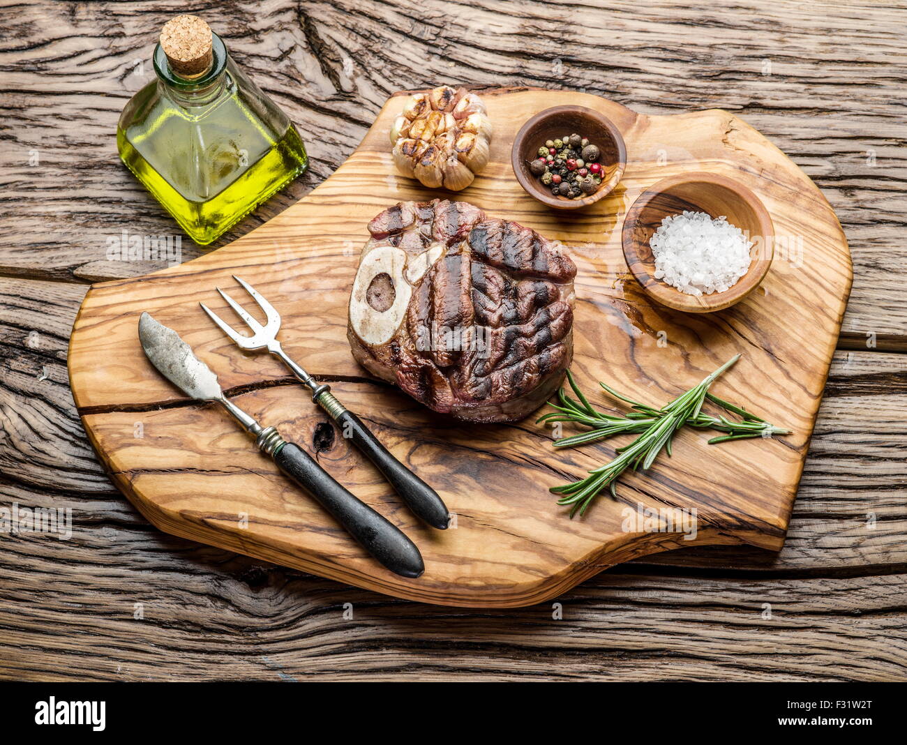 Rindersteaks mit Gewürzen auf einem Holztablett. Stockfoto