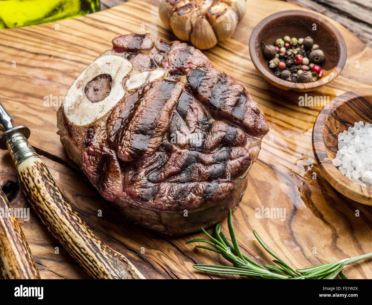 Rindersteaks mit Gewürzen auf einem Holztablett. Stockfoto