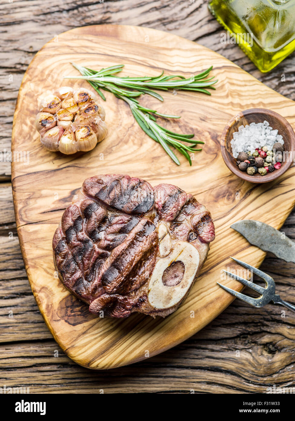 Rindersteaks mit Gewürzen auf einem Holztablett. Stockfoto
