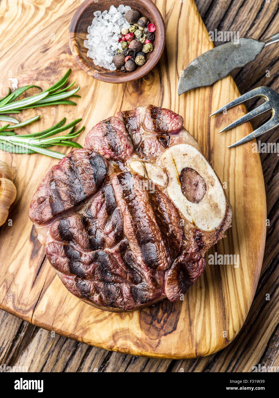 Rindersteaks mit Gewürzen auf einem Holztablett. Stockfoto