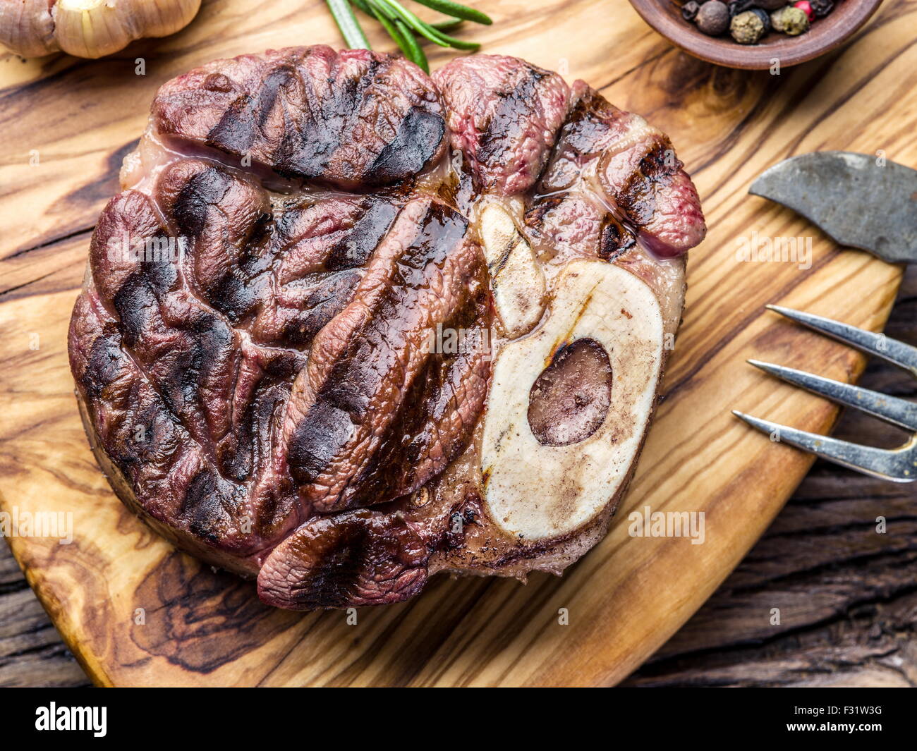 Rindersteaks mit Gewürzen auf einem Holztablett. Stockfoto