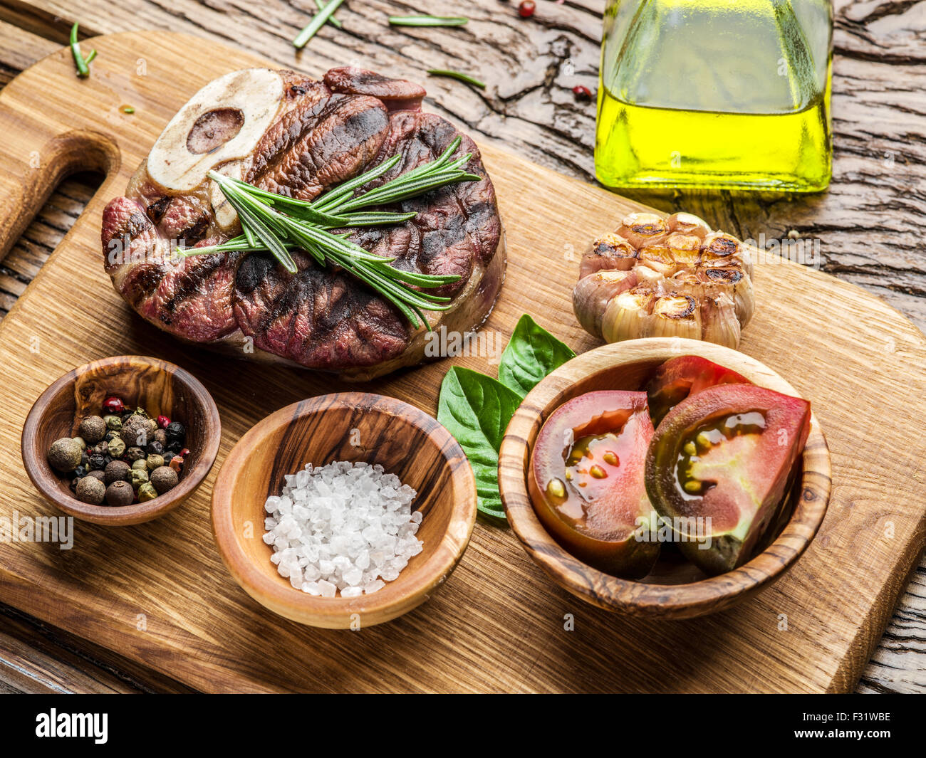 Rindersteaks mit Gewürzen auf einem Holztablett. Stockfoto